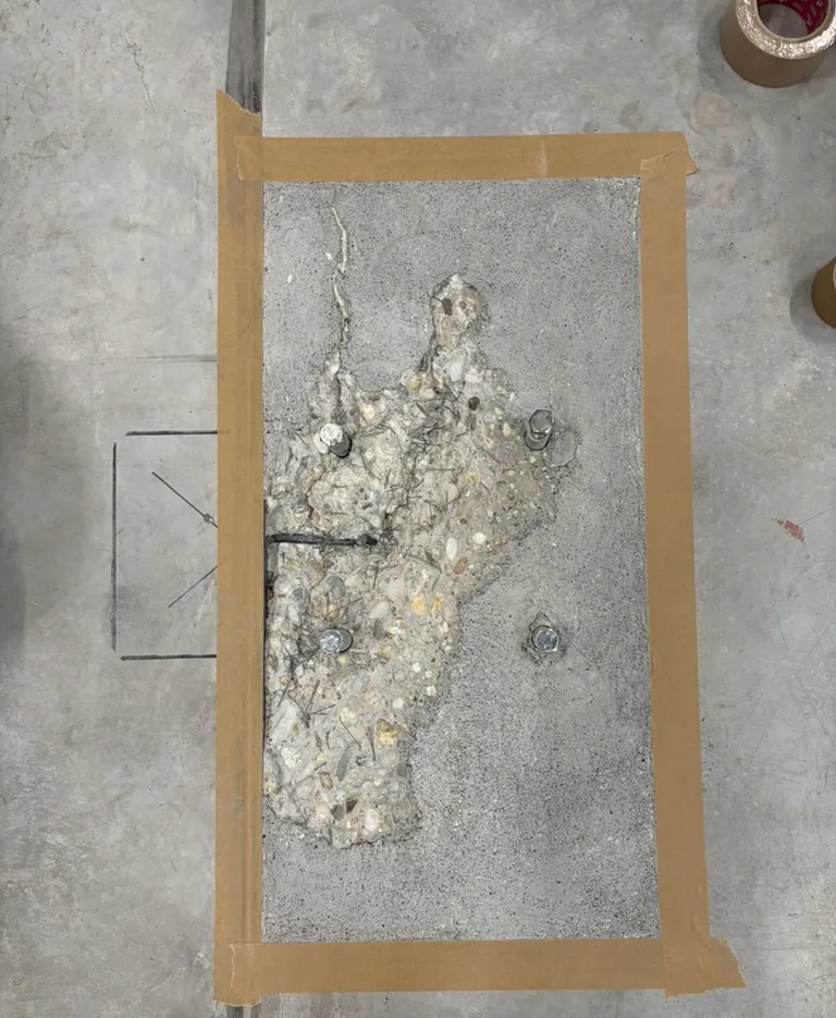 Poškozené místo v betonové podlaze s odkrytým kamenivem