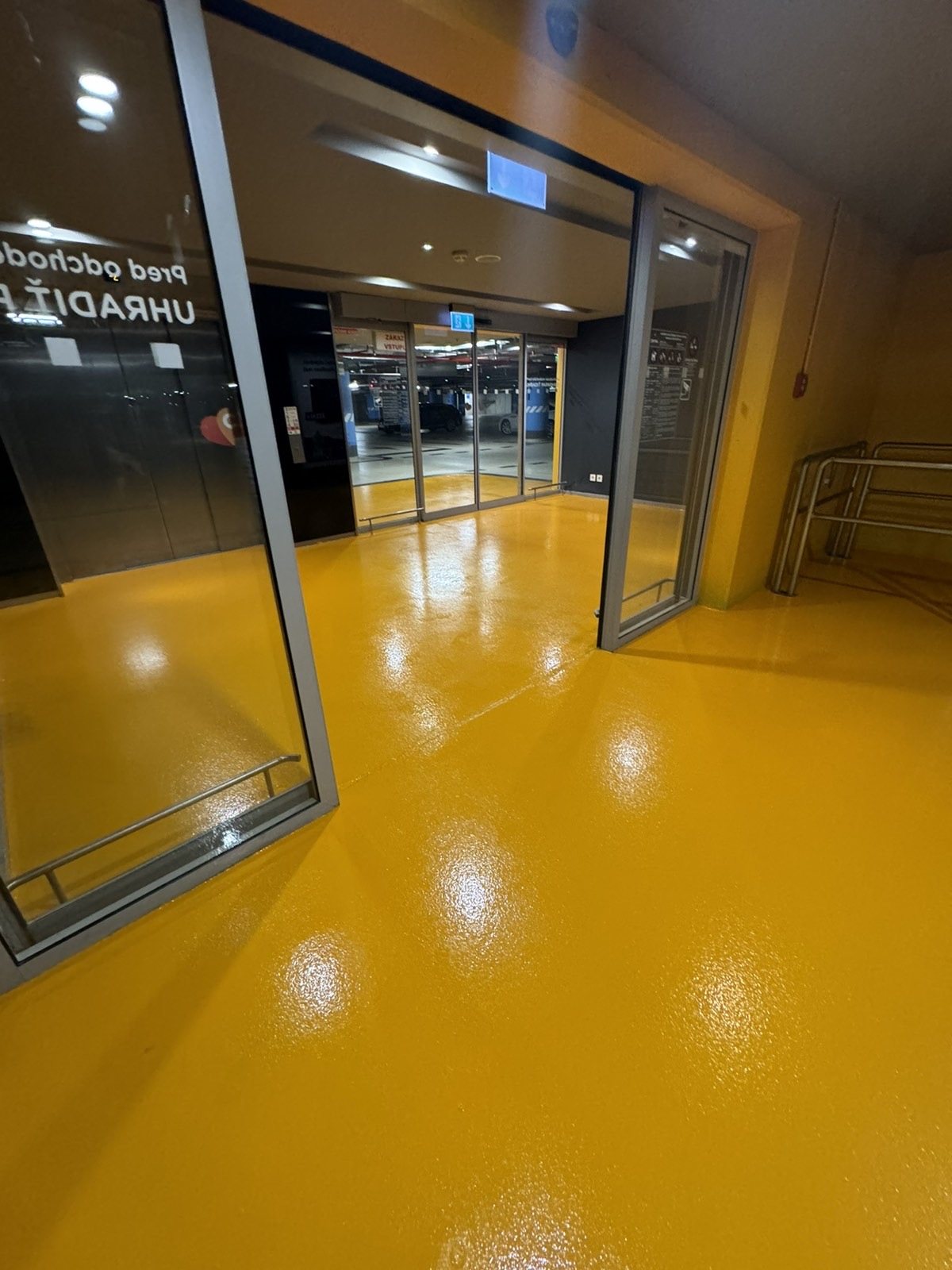 Nákupní centrum — vstupní zóna se žlutou podlahou